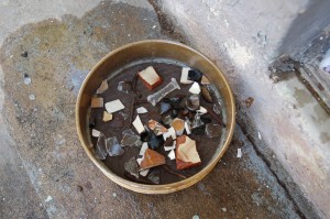 Artifacts from a shovel-test-pit from Papwine. The sieve contains a cut-glass stem from a wine glass, dark green wine bottle glass, cut nails and many types of imported European ceramics.